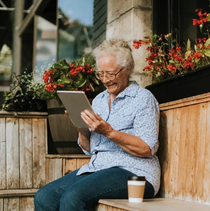 Elderly woman on video call with doctor in her backyard